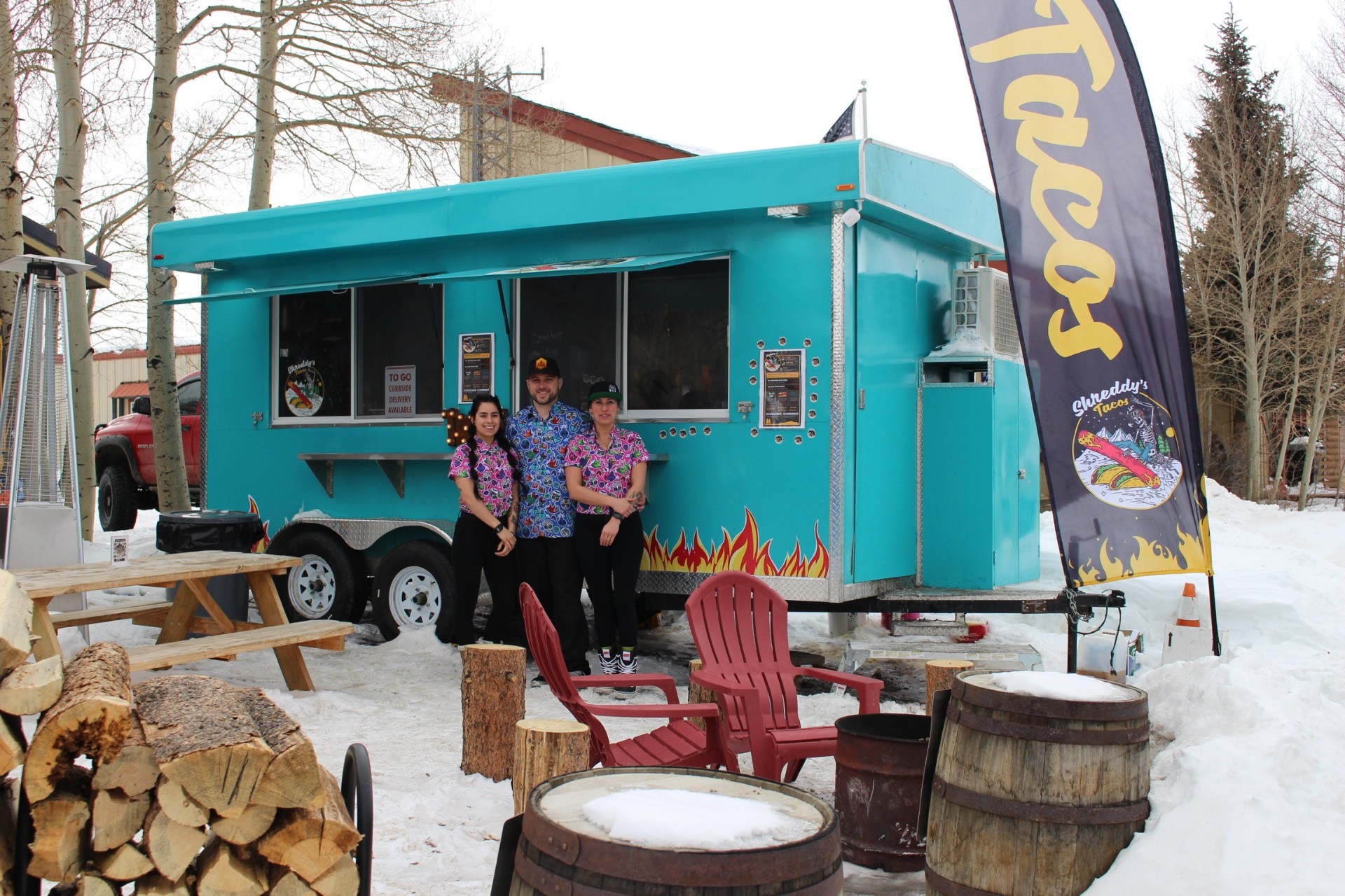 The original teal Shreddy's Tacos food truck with the crew out front in the snow