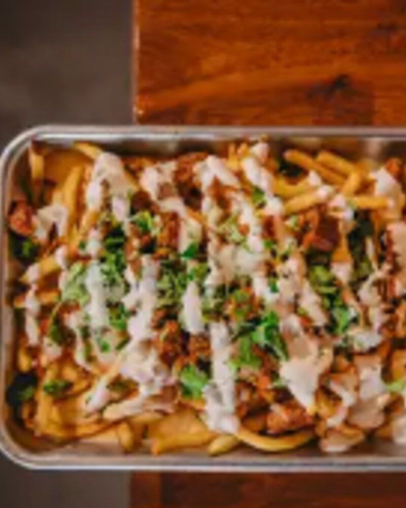 Loaded Papas taco — House fries, queso blanco, protein, cilantro, crema